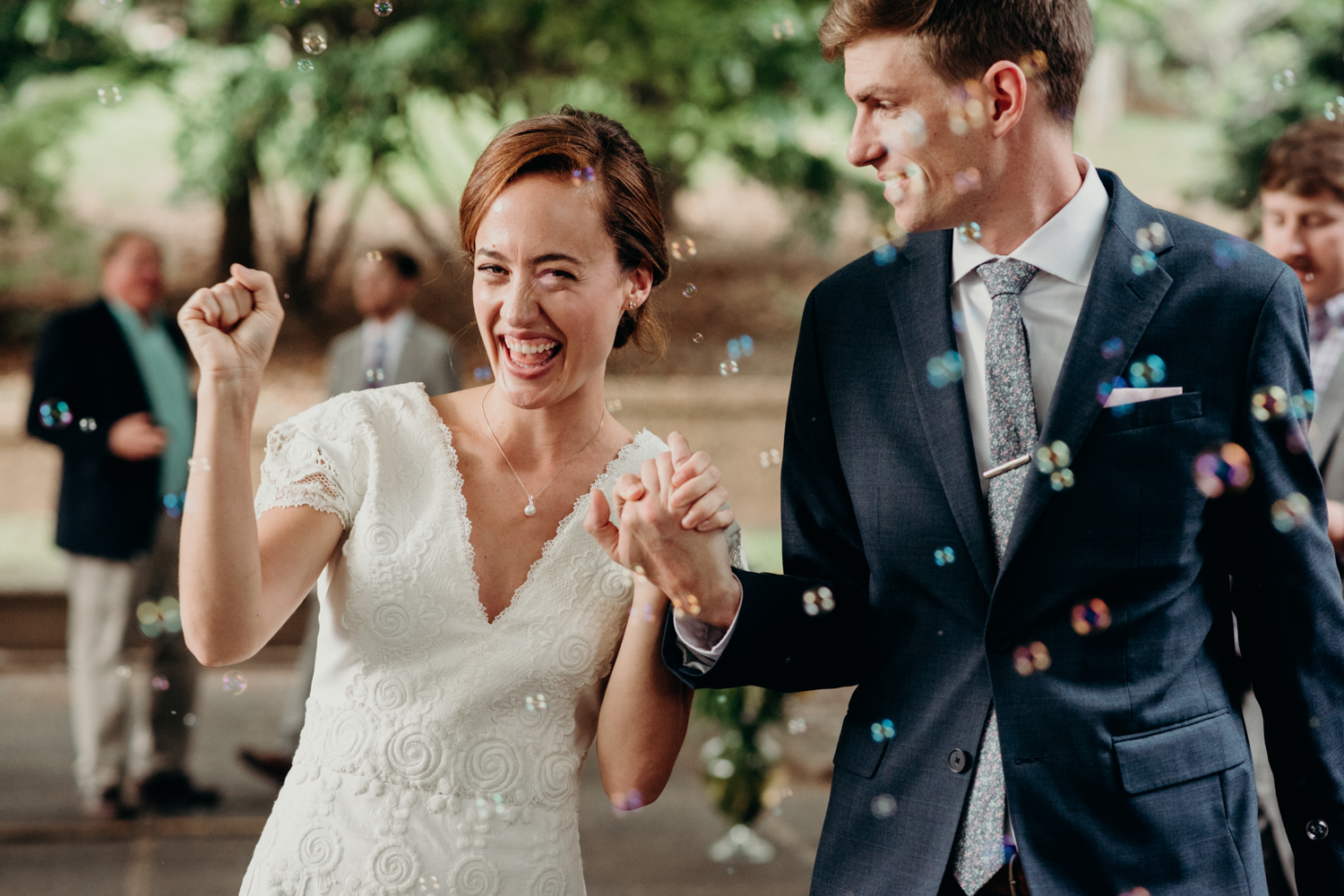 bride and groom walking up the aisle through bubbles