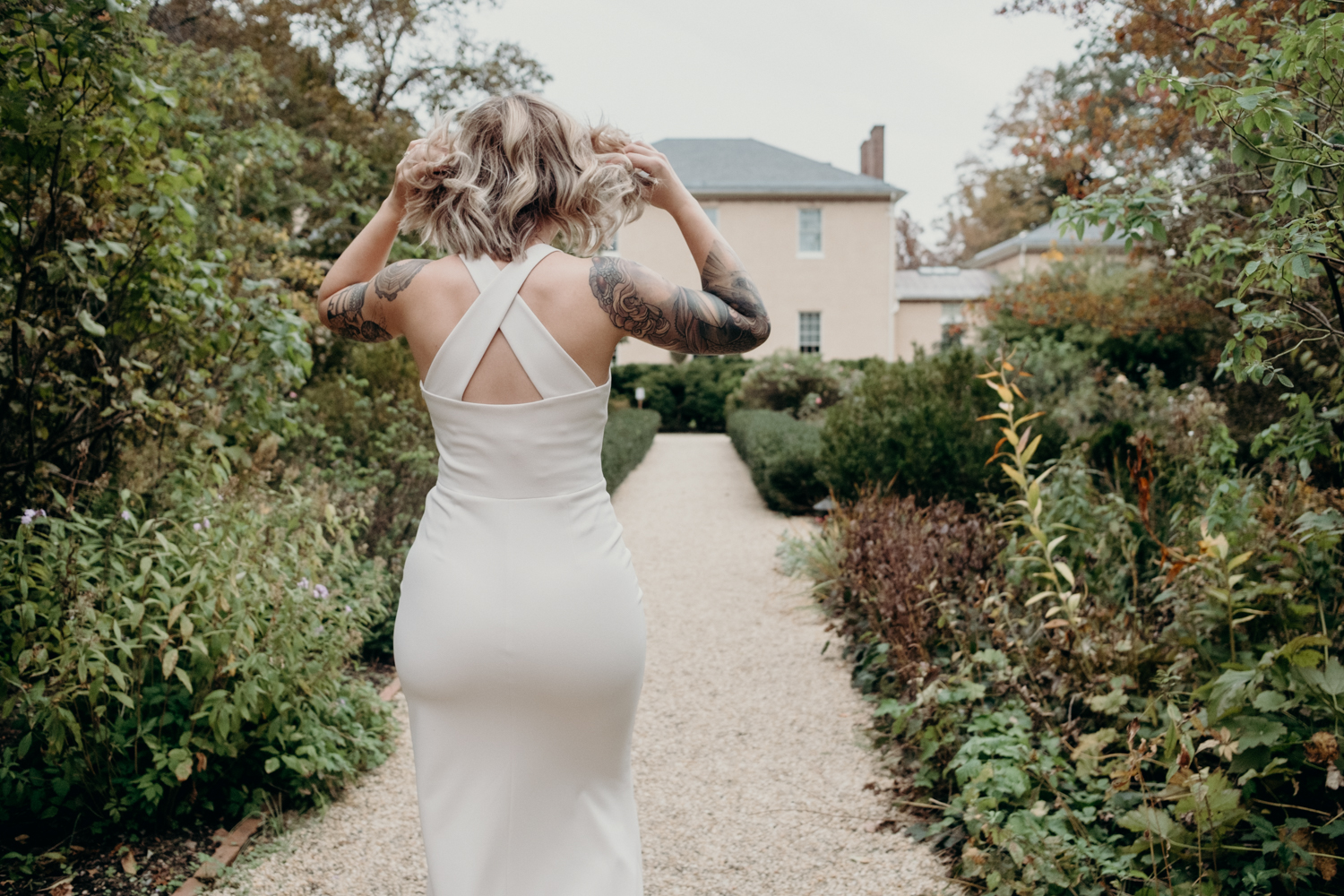 bride walks through gardens at tudor place for first look