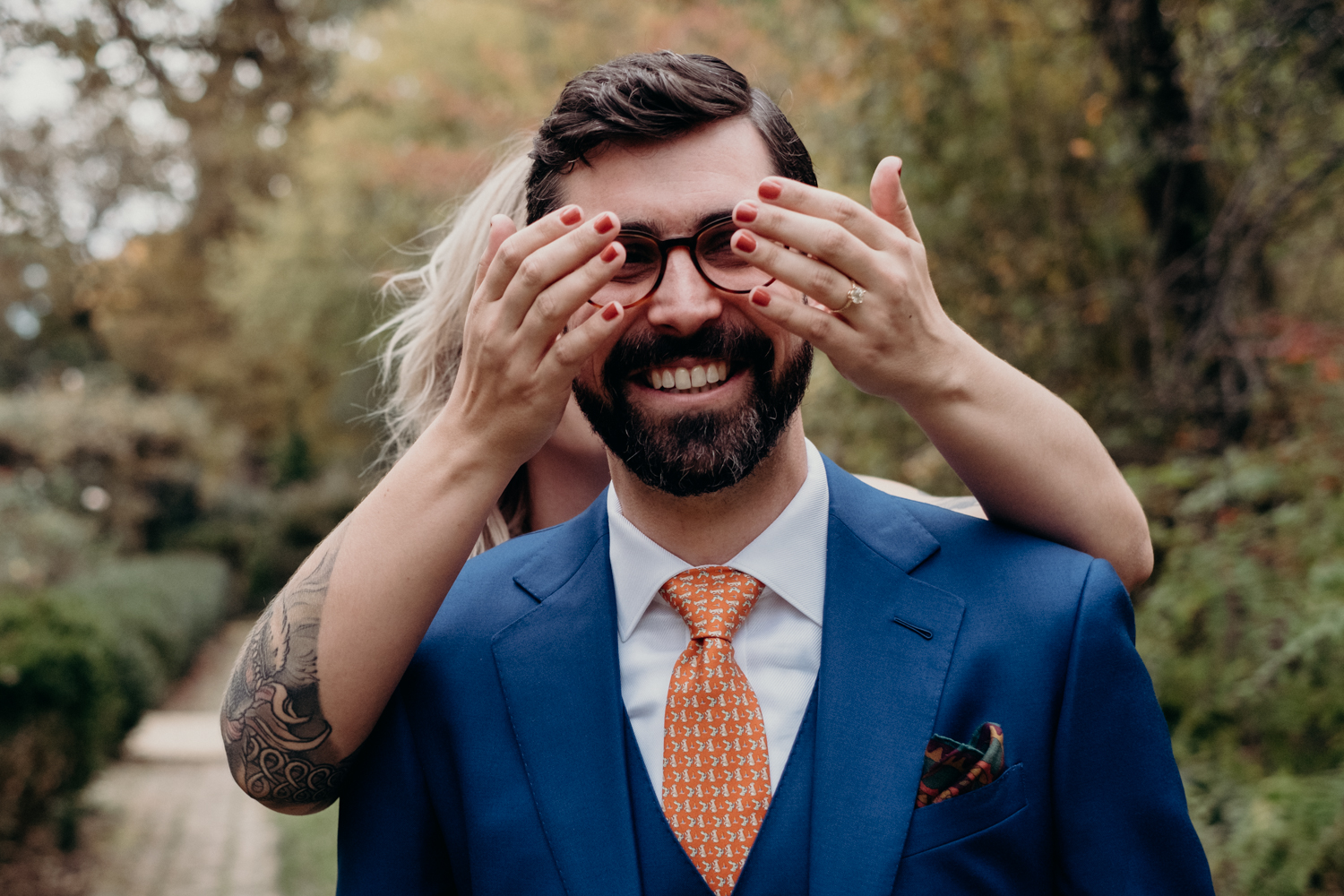 bride covers groom's eyes during first look