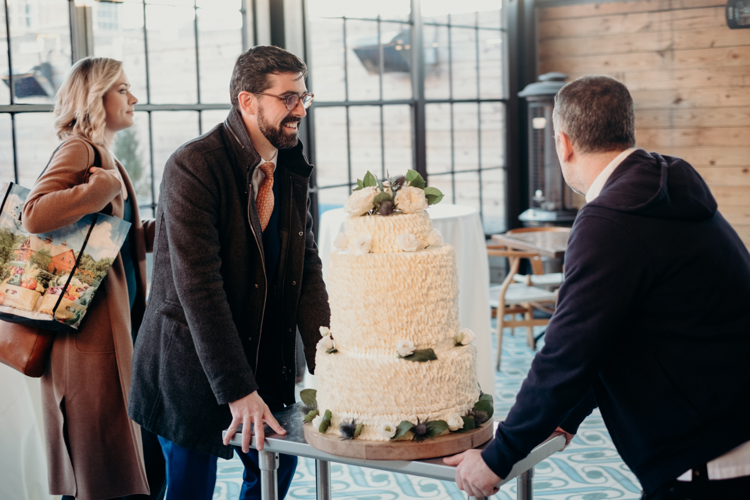 groom wheels in giant wedding cake to reception