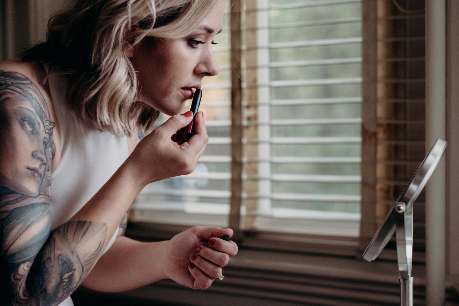 bride putting her lipstick on getting ready at tudor place for wedding