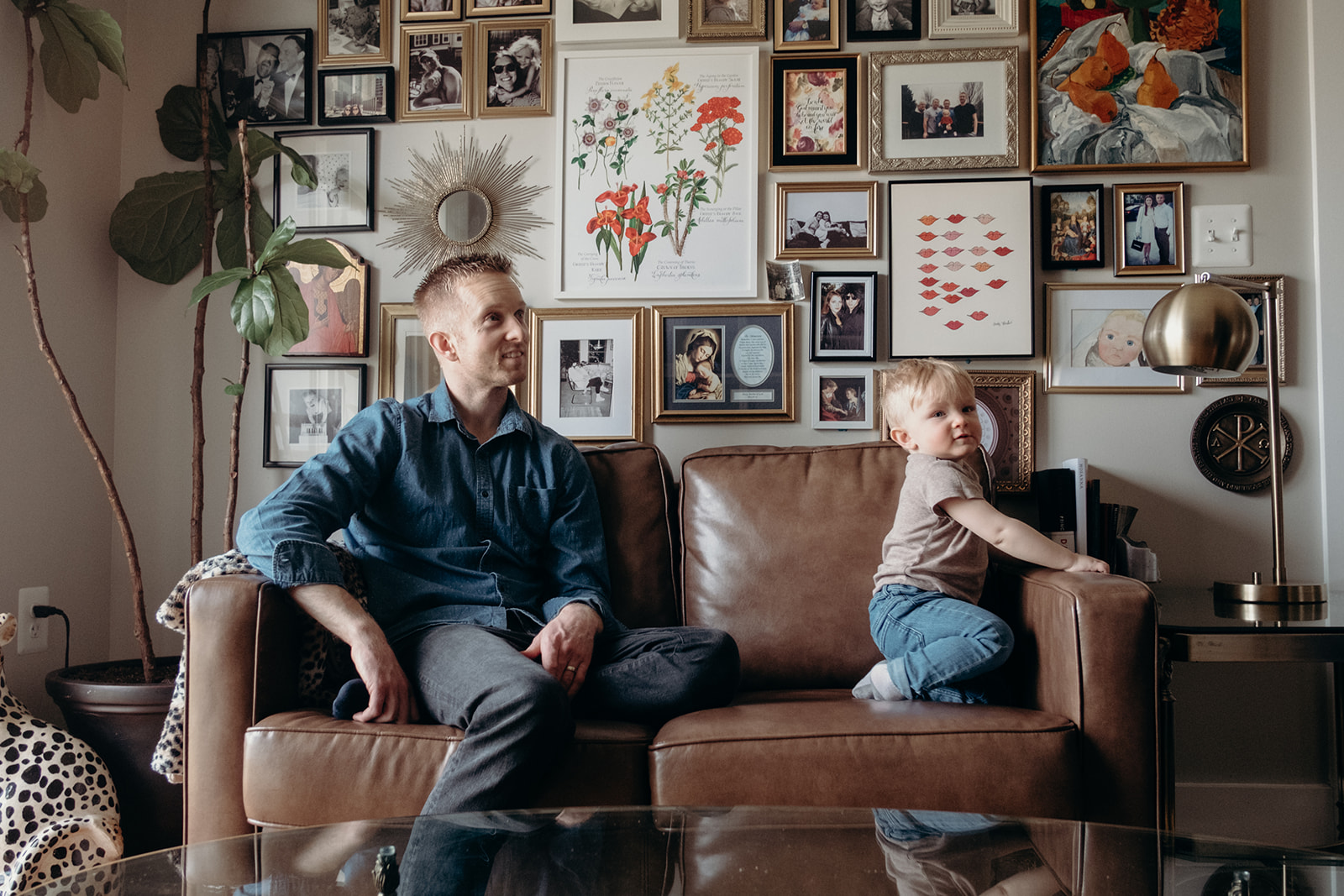 A father and son sit on a couch in their apartment in Washington, DC.