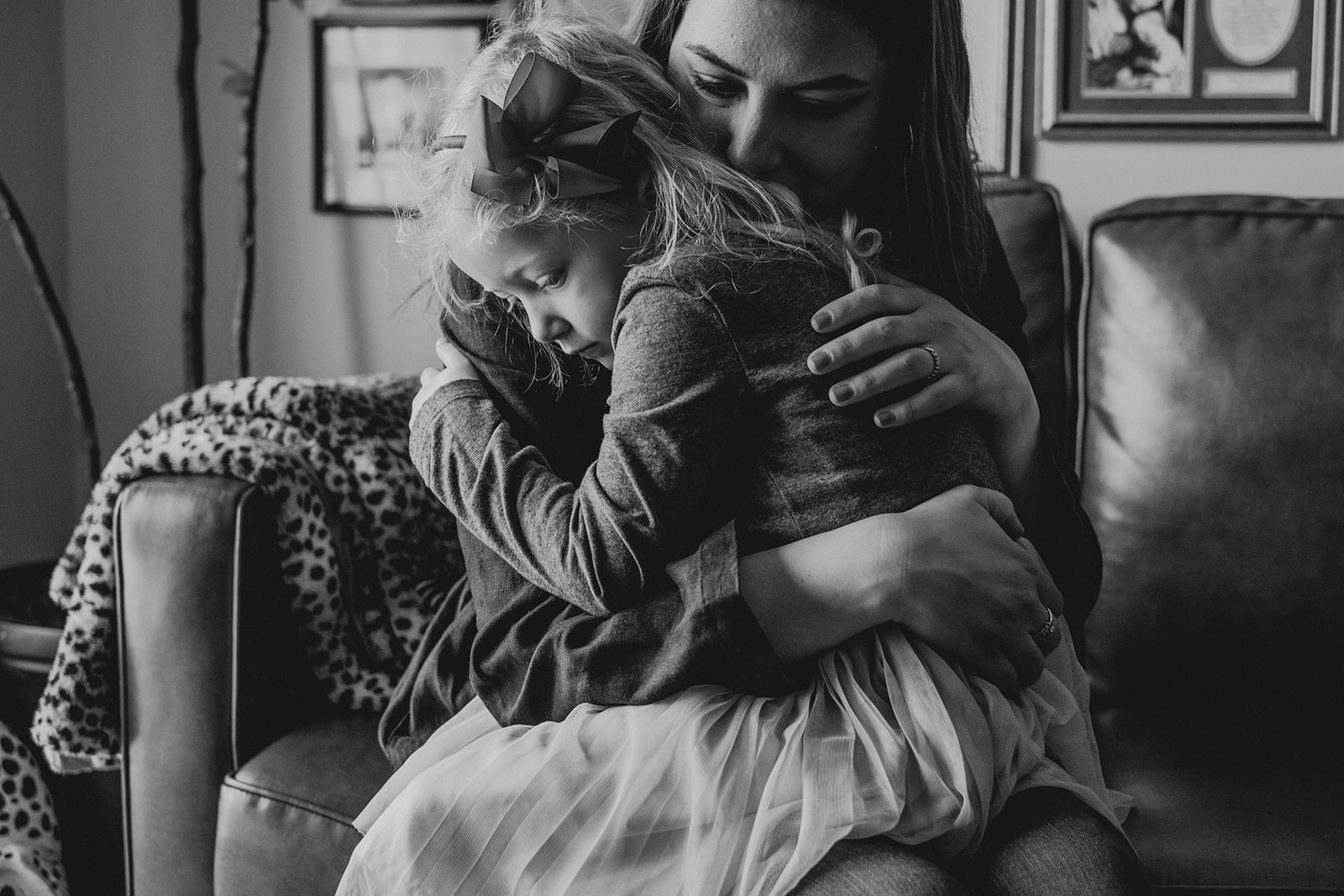 A mother embraces her daughter while sitting on a couch in their apartment in Washington, DC.