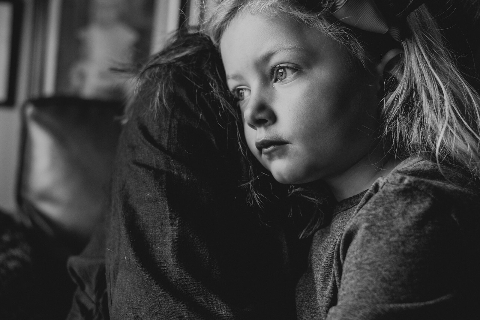 A little girl is held by her mother in their apartment in Washington, DC.