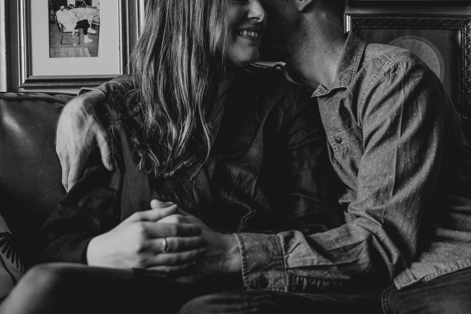 A man kisses his wife while seated on a couch in their apartment in Washington, DC.