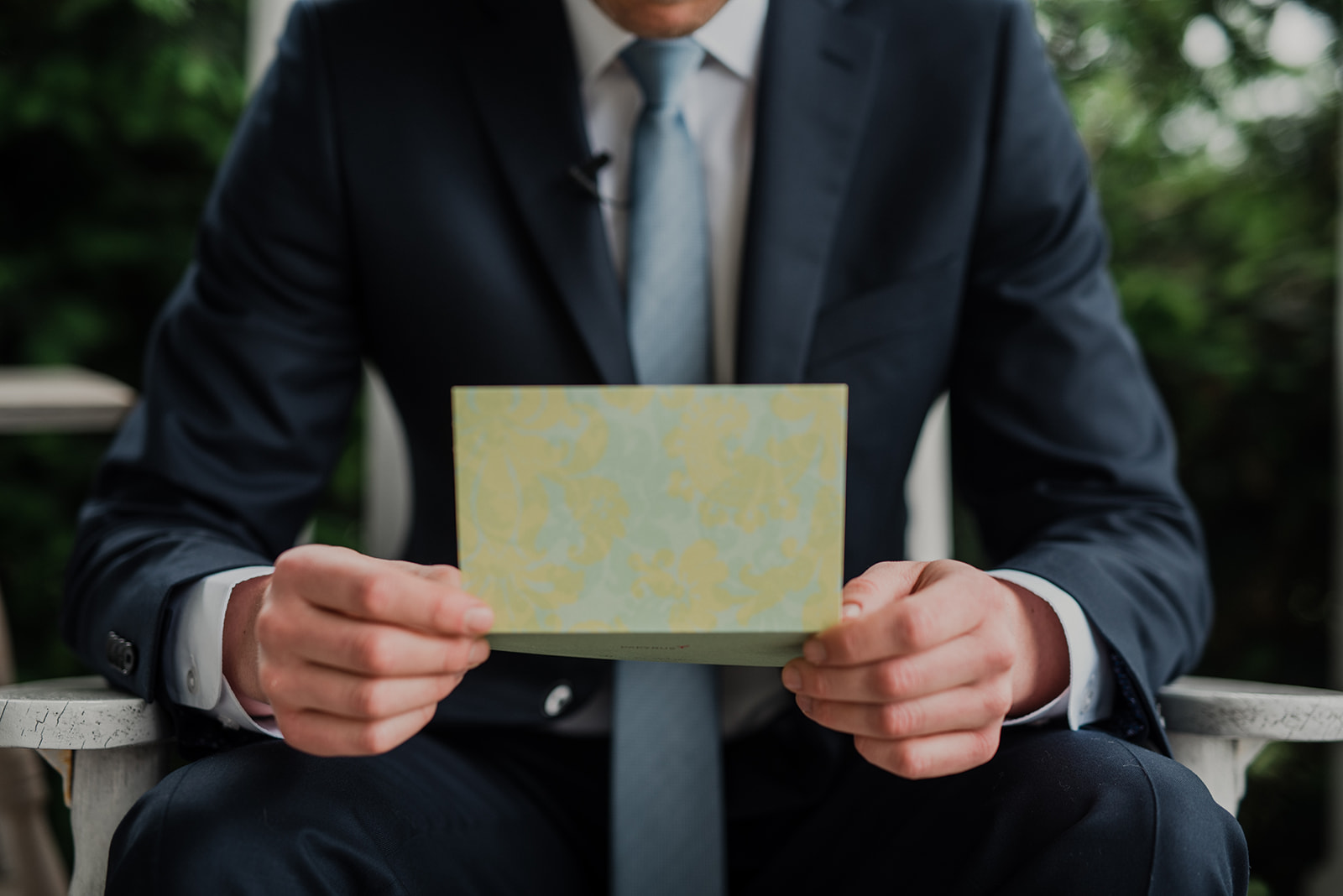 A groom holds a letter from his bride before their outdoor wedding ceremony at Blue Hill Farm in Waterford, VA. 