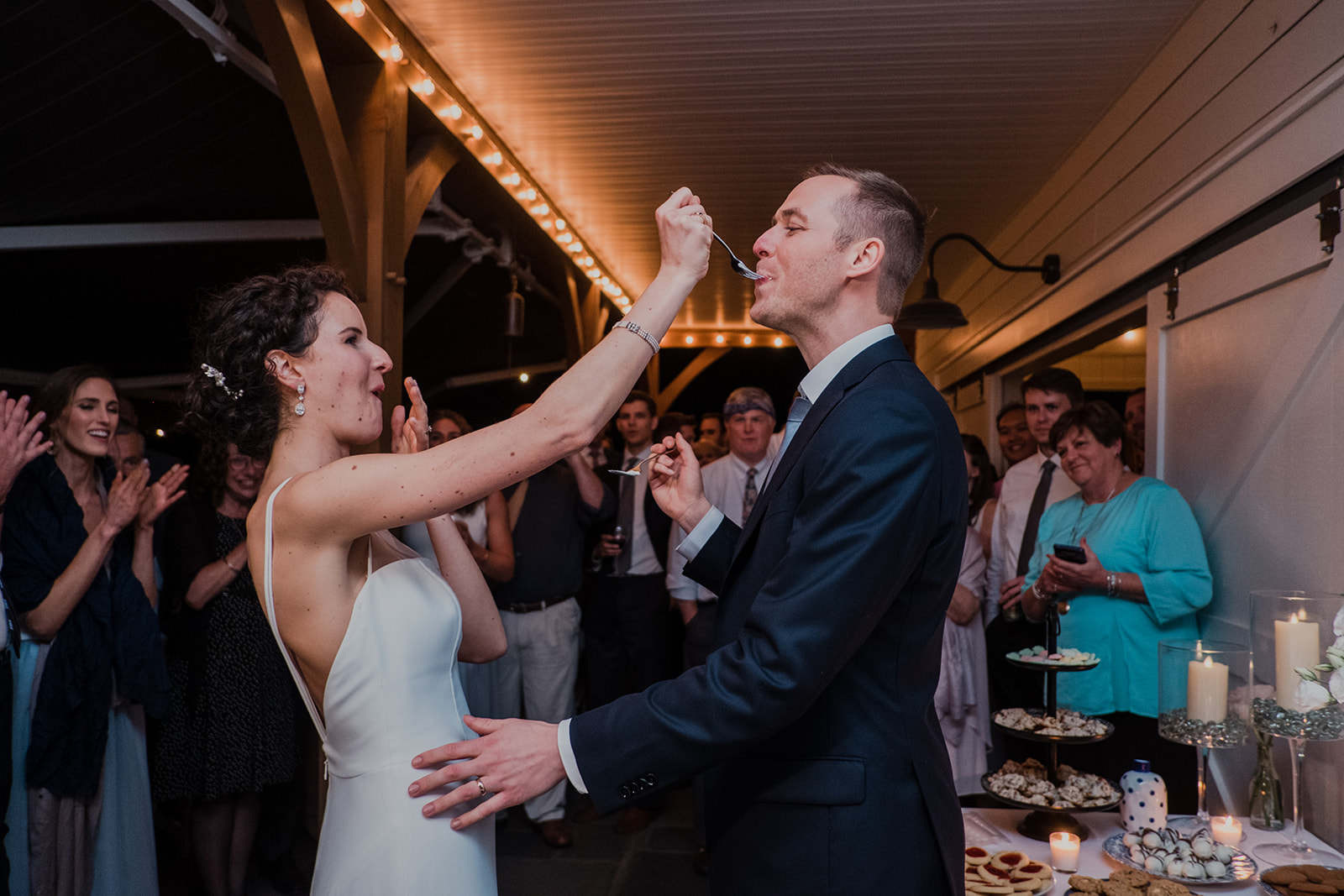 A bride feeds her groom cake during their wedding reception at Blue Hill Farm in Waterford, VA.