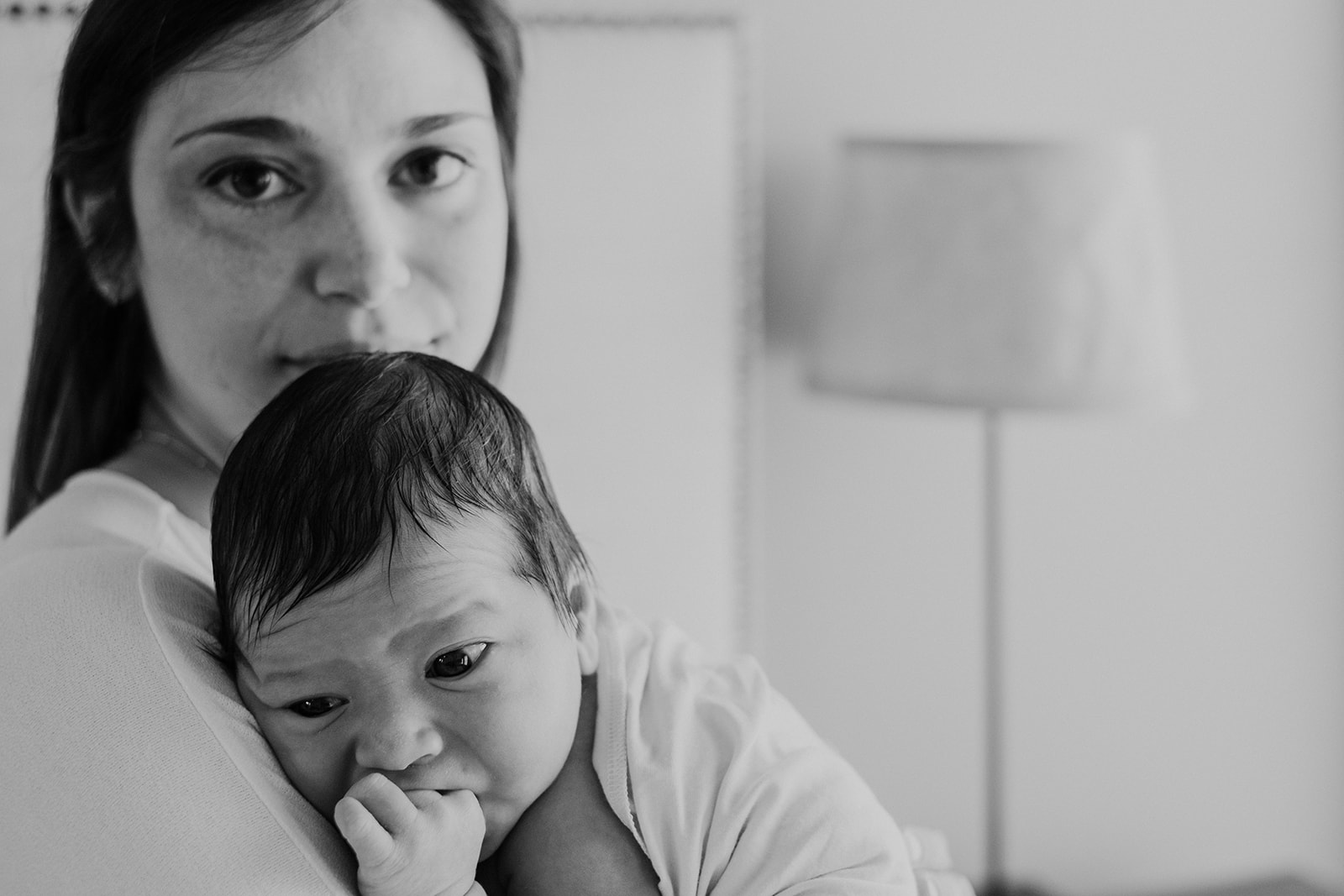 A mother holds her son after nursing him during and in home family photography session. 