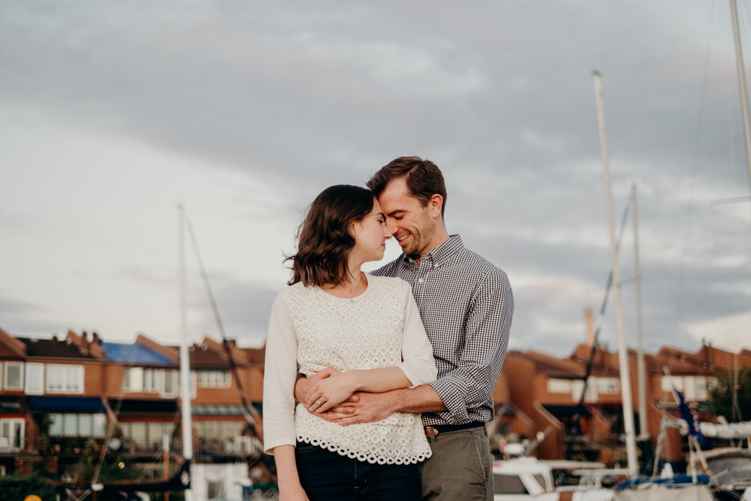 A man holds his fiancé during an engagement session on the Inner Harbor of Baltimore, MD. 