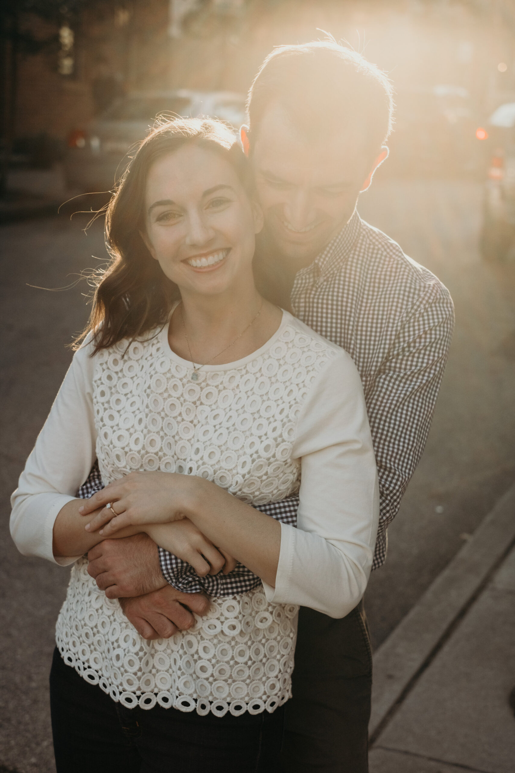 A couple embraces during sunset on a street in Baltimore, MD.