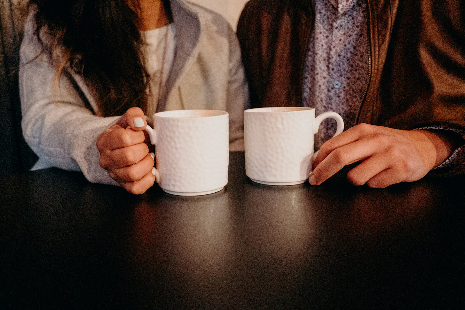 A couple holds their coffee cups at SideBar coffee in downtown Leesburg, VA during their engagement session. 