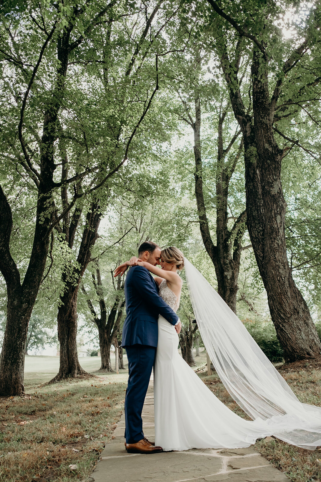 A bride and groom kiss on a path at the Retreat at Eastwood Farm in Warrenton, VA. 