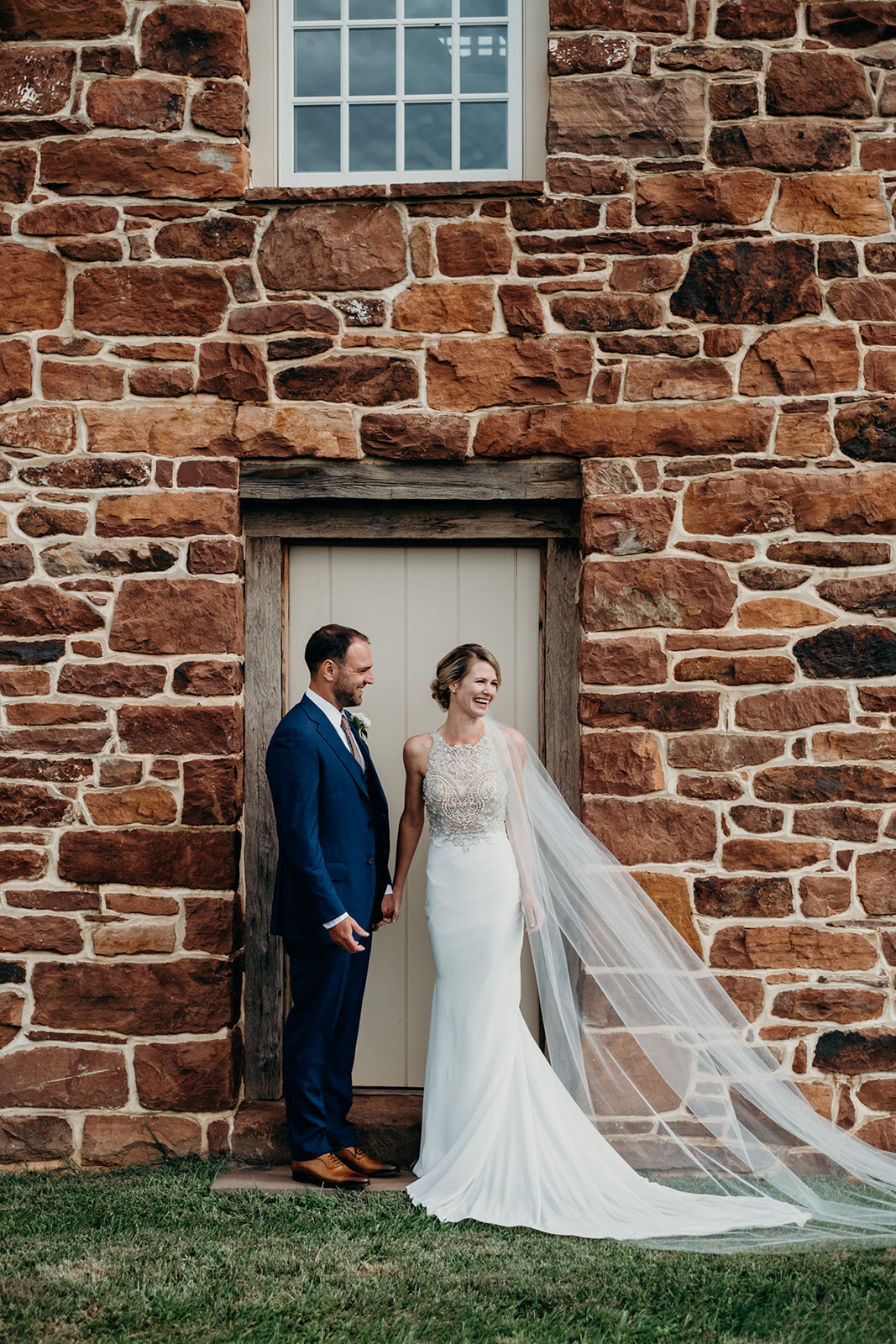 A bride and groom stand in a doorway of a historic building at the Retreat at Eastwood Farm in Warrenton, VA. 