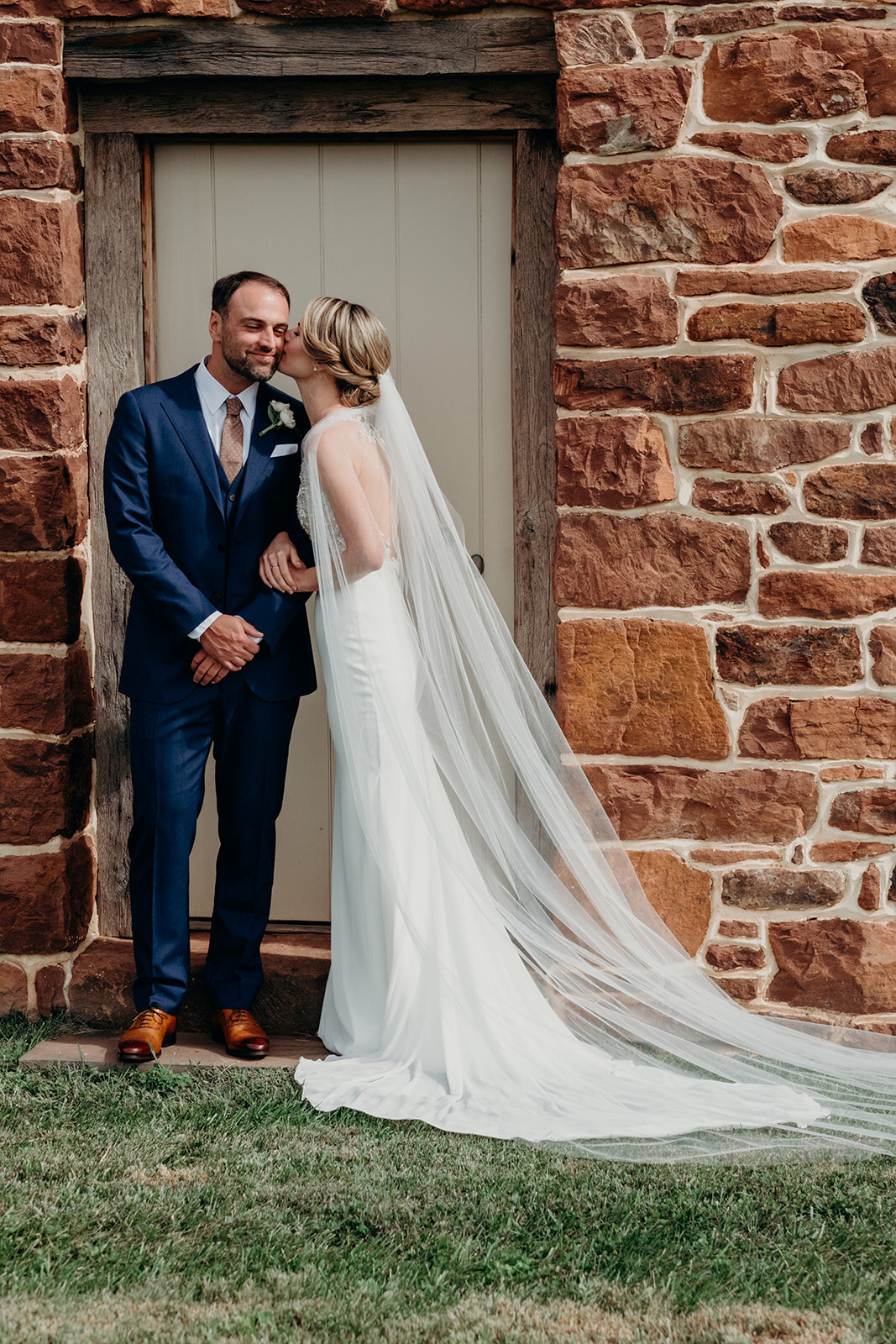 A bride kisses her groom before their outdoor garden wedding at the Retreat at Eastwood in Warrenton, VA.