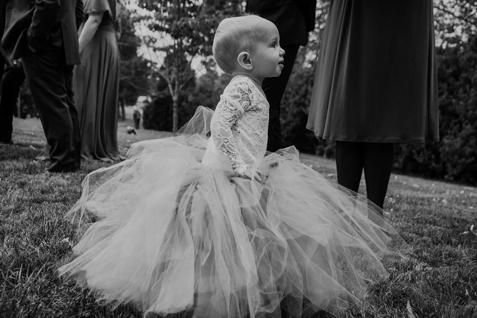 A little flower girl toddles off before the outdoor garden wedding at the Retreat at Eastwood Farm in Warrenton, VA.