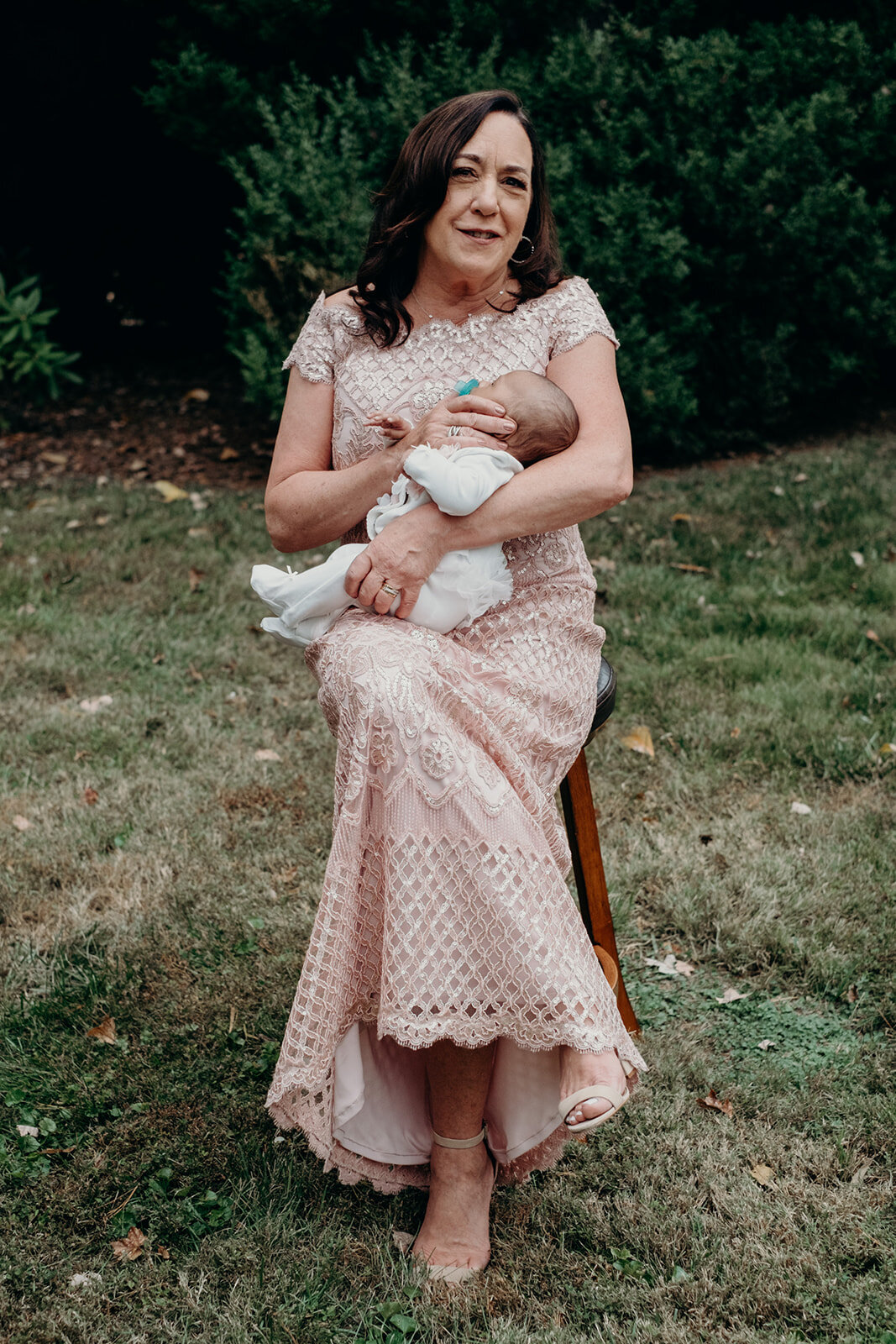 A grandmother holds her newborn baby granddaughter at a wedding at the Retreat at Eastwood Farm in Warrenton, VA.