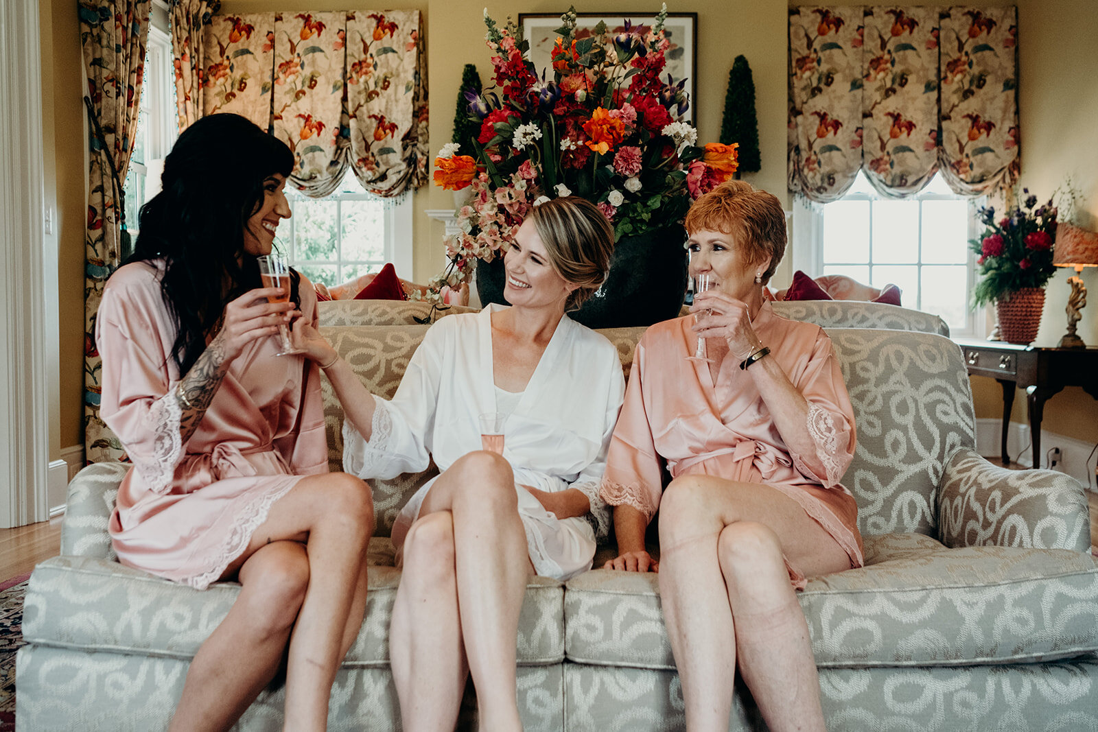 A bride sits with her mother and sister before her outdoor garden wedding at The Retreat at Eastwood Farm in Warrenton, VA.