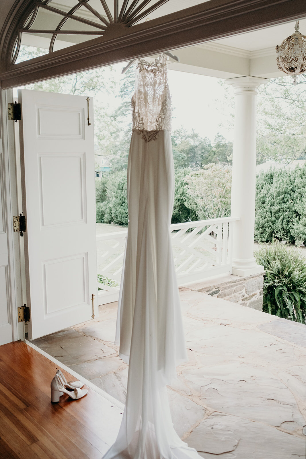 A beaded satin wedding dress hangs in a doorway at the Retreat at Eastwood in Warrenton, VA.