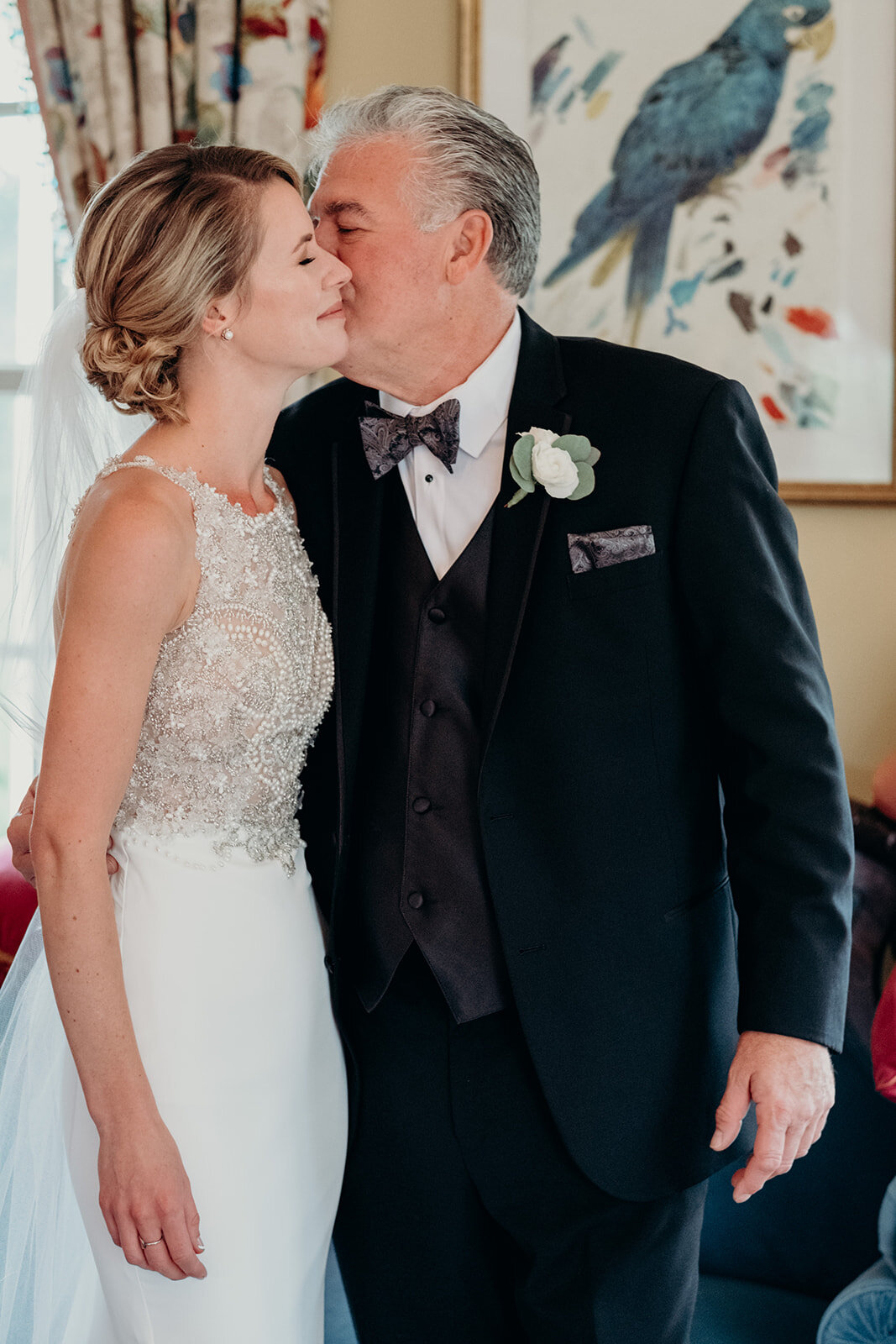 A father kisses his daughter on her cheek after seeing her for the first time on her wedding day at the Retreat at Eastwood Farm in Warrenton, VA.