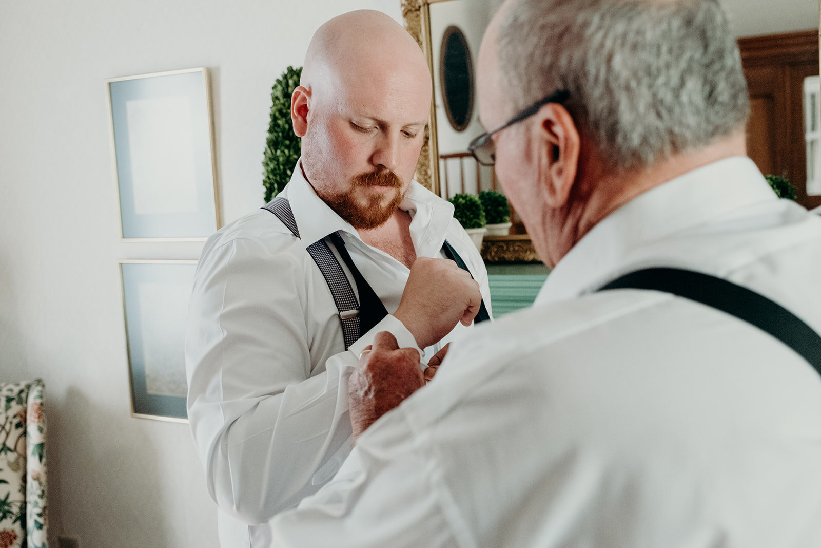 The groom is helped by his father as he gets ready for his outdoor wedding ceremony. 