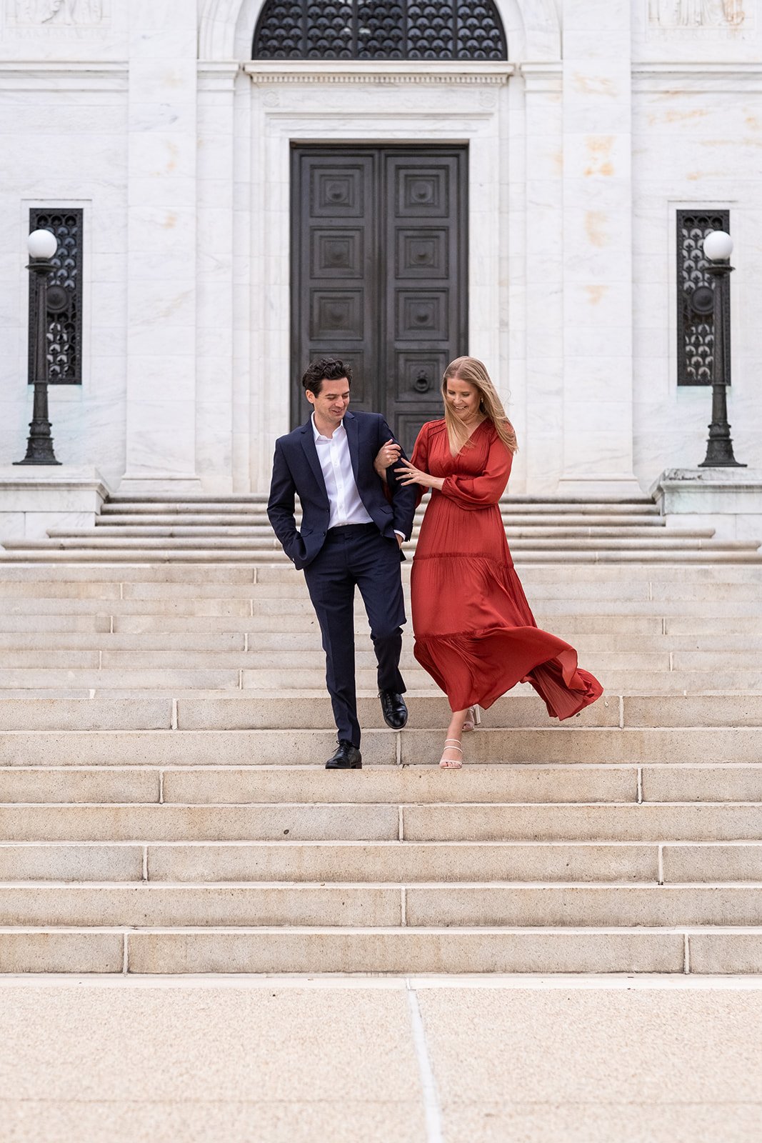 An engaged couple walks down the stairs at the American Pharmacy Institute Building in Washington, DC.